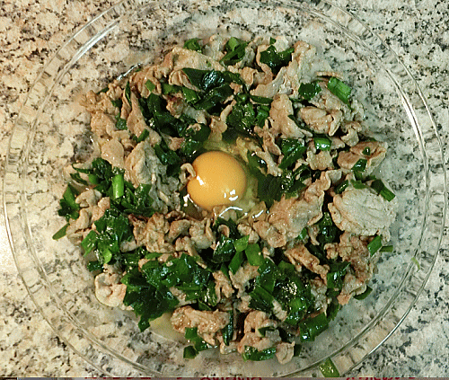 焼いた豚バラとニラを耐熱皿にあけて、真ん中に卵を落とす